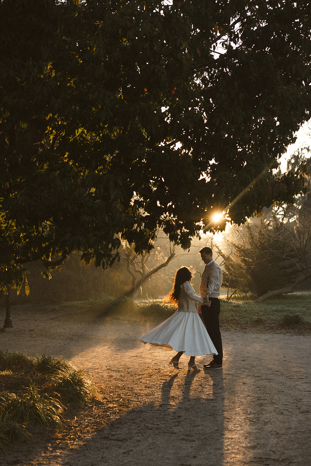 A couple dancing and posing during golden hour for their engagement shoot.