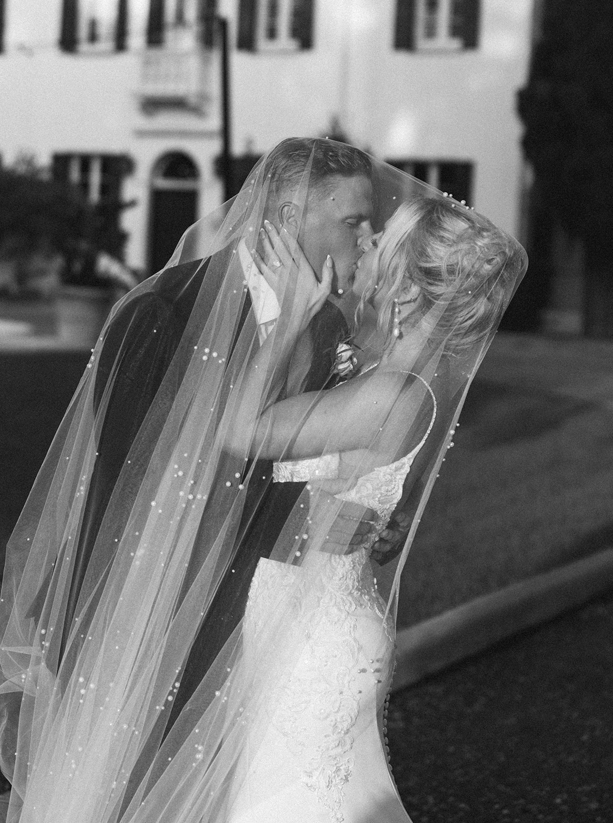 A bride and groom kissing under the bride's veil at their Georgia wedding.
