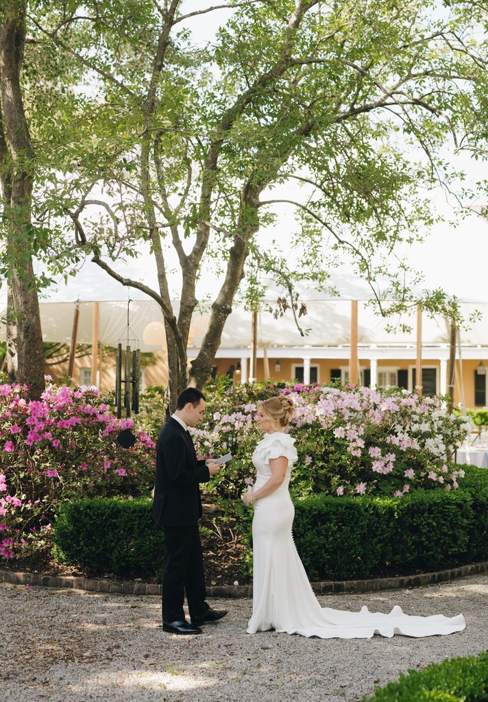 Bride and groom's first look in the garden at the Thomas Bennett House, surrounded by pink azaleas and boxwood hedges