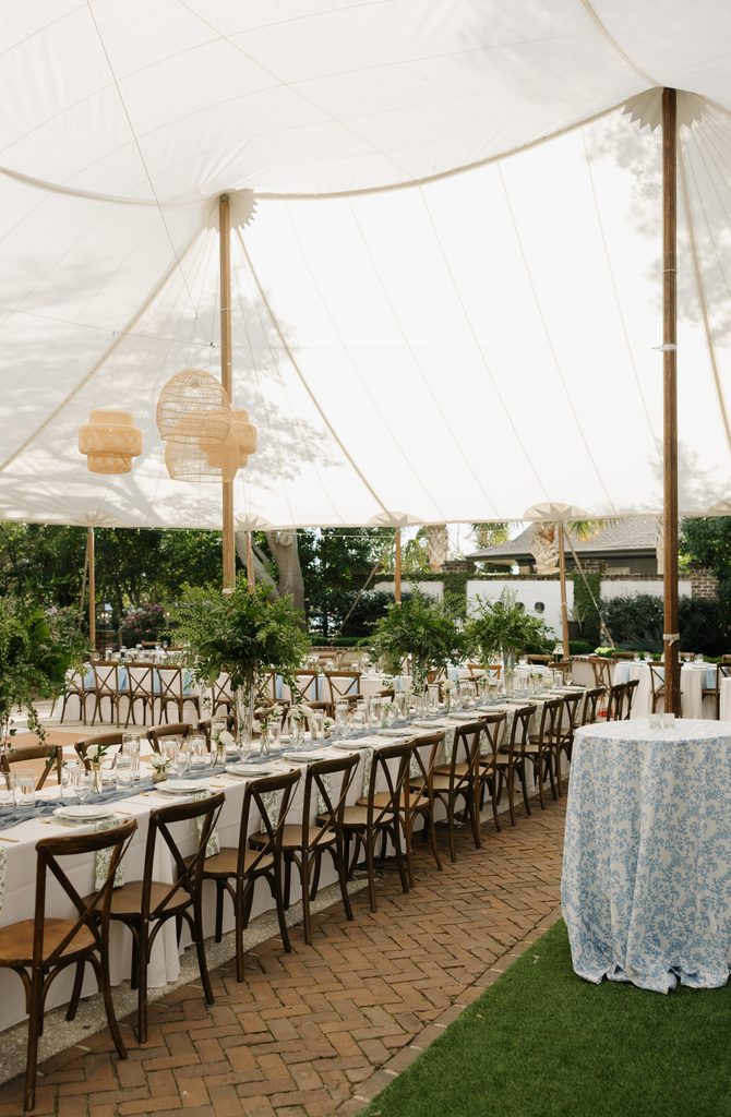 Tented garden reception at the Governor Thomas Bennett House with long tables, wooden cross-back chairs and blue toile linens